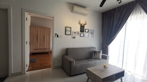 Ein modernes Wohnzimmer mit einem grauen Sofa, einem Holztisch und einem Deckenventilator.