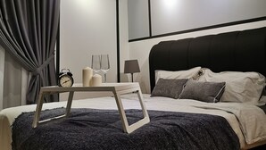 Ein modernes Schlafzimmer mit Bett, Nachttisch, Lampe und Deckenventilator.