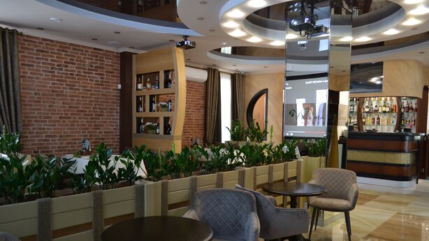 A lobby with a brick wall, a bar area, and seating with tables and chairs. - Paloma House (Kharkiv)