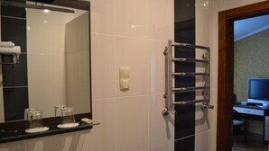 A bathroom with a mirror, towel rack, and a shelf with toiletries. - Paloma House (Kharkiv)