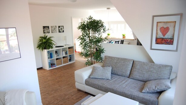 Ein modernes Wohnzimmer mit einem weißen Sofa, einem Couchtisch und einem Bücherregal.