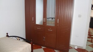 Ein Schlafzimmer mit einem Bett, einem Kleiderschrank und einem Schachbrettfußboden.