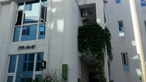 Un edificio de varios pisos con fachada blanca, ventanas amplias y un letrero que dice "City Inn".