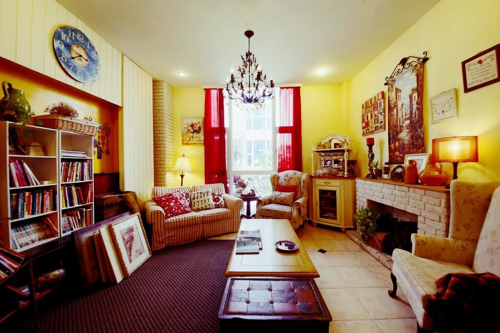 A cozy living room with a fireplace, a bookshelf, and a comfortable sofa.