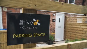 A sign for Hive Apartments indicating a parking space. - The Hive Apartment (Stockport)