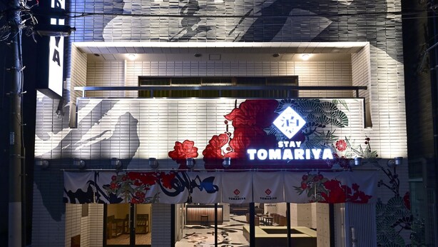 A hotel entrance with a sign reading "STAY TOMARIYA" and a floral design on the facade. - Hotel Tomariya Ueno - Hostel (Tokyo)