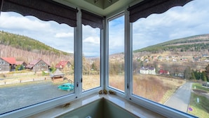 A room with a large window overlooking a rural landscape with houses and a road. - Apartament Cichy - Apartamenty 5d (Swieradow-Zdroj)