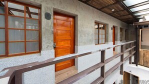 A building with a wooden door, windows, and a balcony with a wooden railing. - 158 Hostel (Tainan)