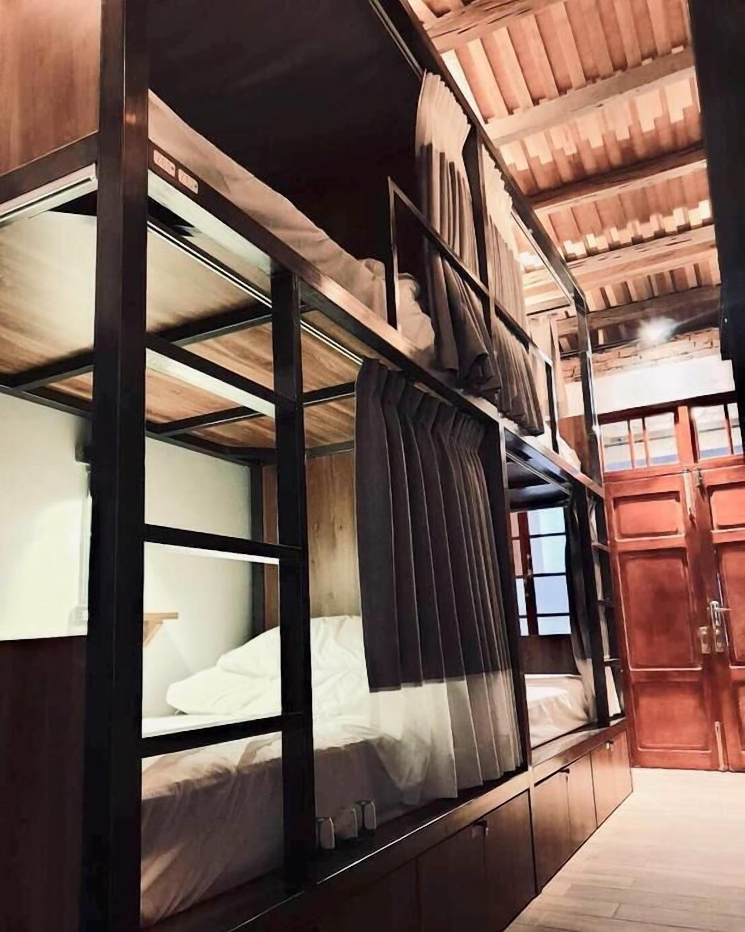 A bunk bed room with wooden walls and a sloped ceiling.