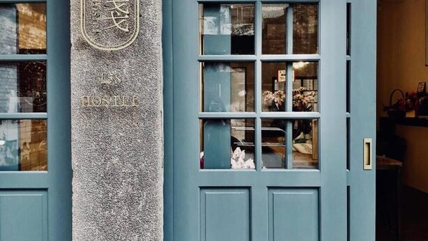 A blue door with a stone pillar and a light fixture. - 158 Hostel (Tainan)