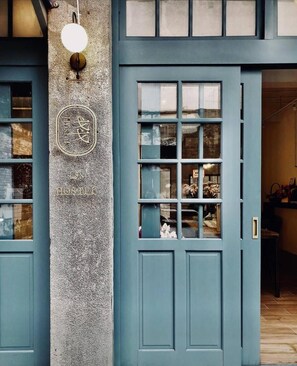 A blue door with a stone pillar and a light fixture. - 158 Hostel (Tainan)