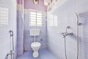 Ein kleines Badezimmer mit Toilette, einem Fenster und einer Dusche.