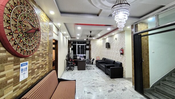Eine Lobby mit Wandverkleidung, einer Bank, einer Chandelierleuchtre und einer Treppe.