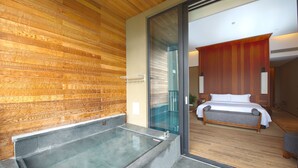 Un baño moderno con pared de madera, cabina de ducha de vidrio y zona de ducha independiente.