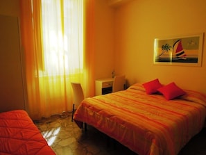 Una habitación de hotel con cama, escritorio y una silla.