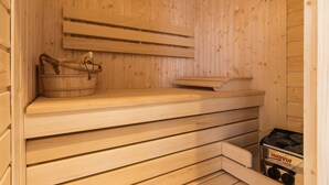 A sauna with wooden benches and a bench with a towel. - Apartament z Sauną pod Świerkami - Apartamenty 5d (Karpacz)