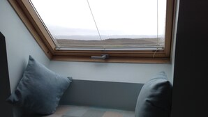 A window seat with a view of a distant landscape. - Hazelbank (Uig)