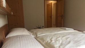 Una habitación de hotel con una cama grande, cabecera de madera y un armario de madera.