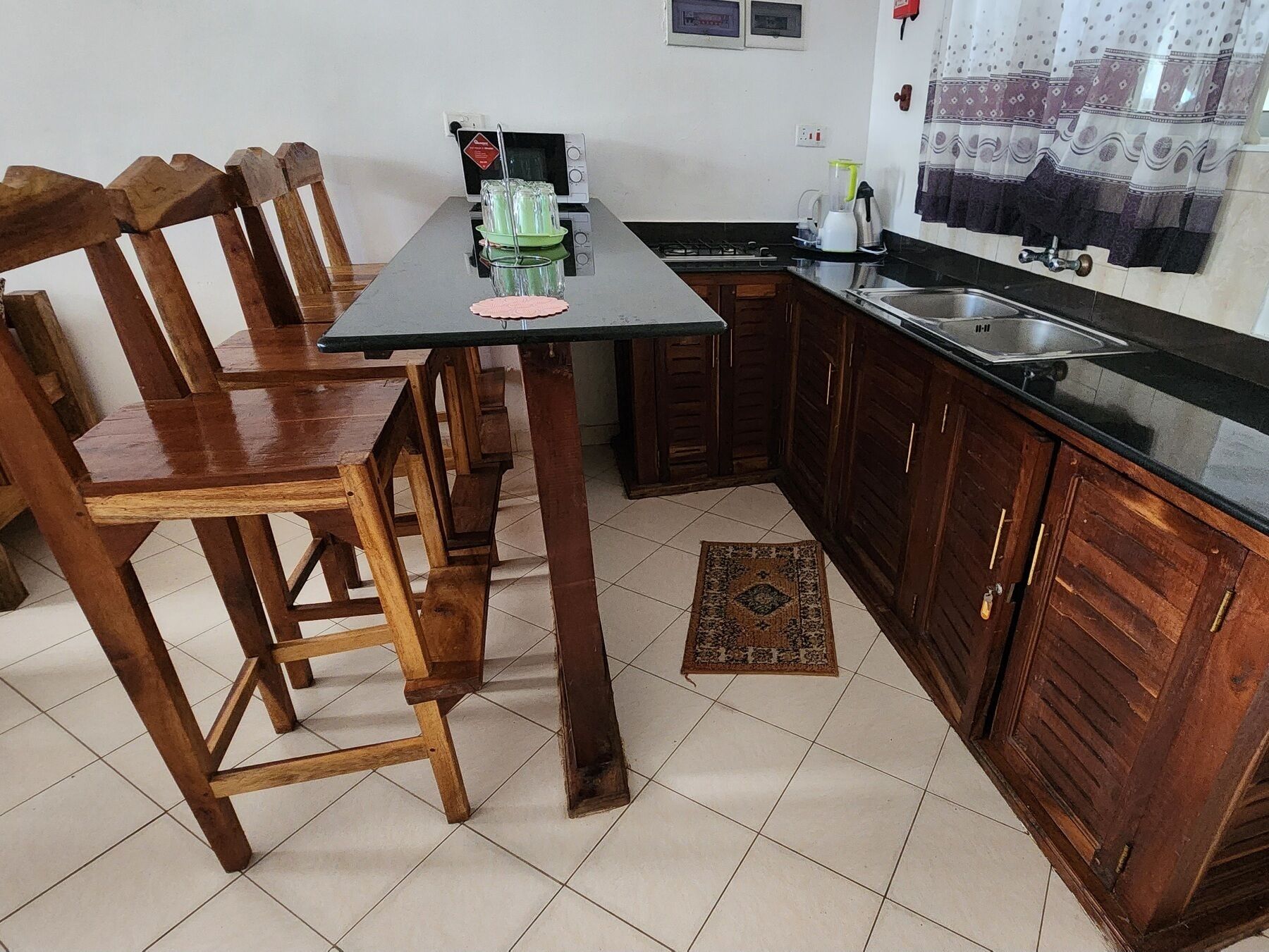 Una cucina con sedie in legno, un tavolo, un lavello e pensili.