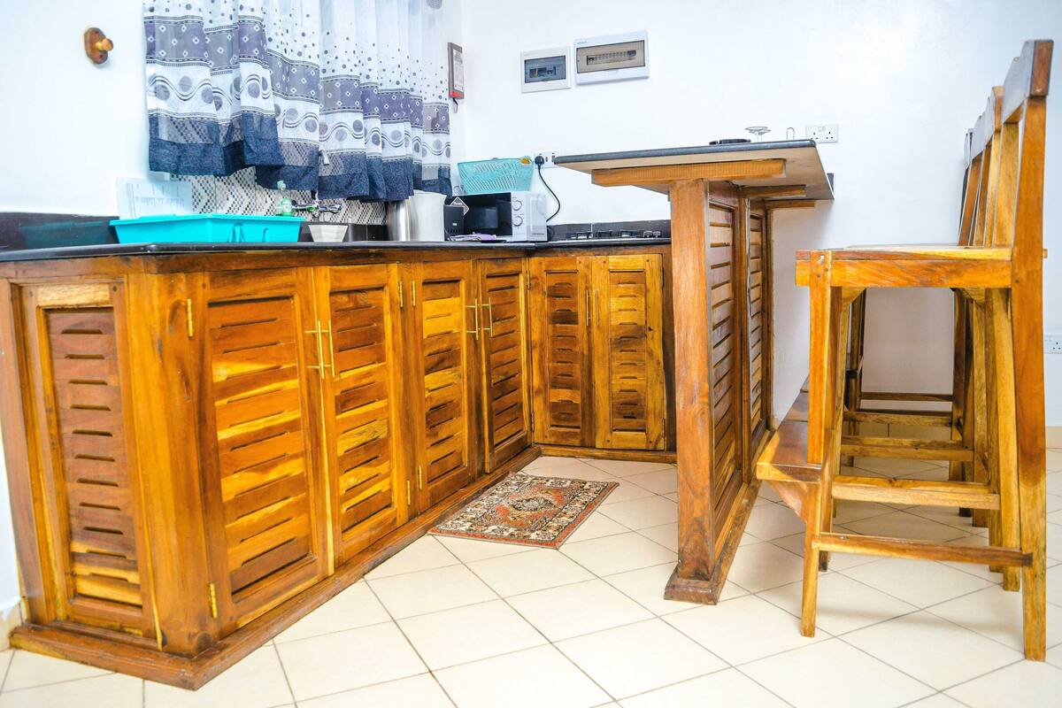 Una cocina con armarios de madera, un microondas y un lavabo.