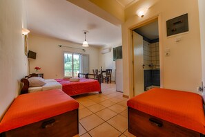 Ein Hotelzimmer mit zwei Betten, einem Schreibtisch und einer Dusche.