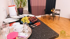 A dining table set with plates, glasses, and utensils, a potted plant, and a coffee maker. - My City Apartments am Naschmarkt (Vienna)