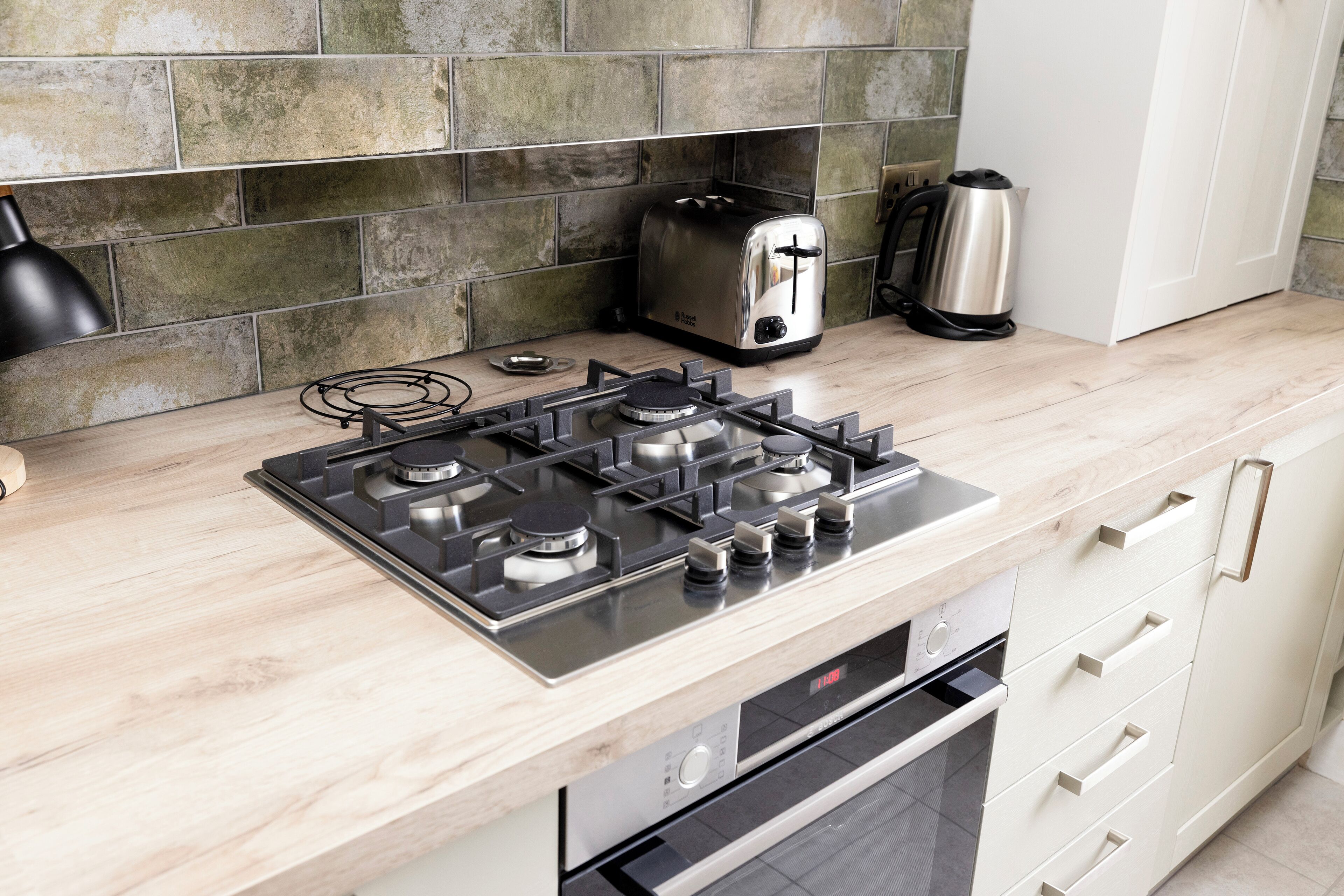 Eine moderne Küche mit einem Gasherd, einem Toaster und einem Wasserkocher.