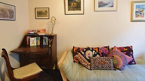 A bedroom with a bed, a desk, a chair, and a bookshelf.