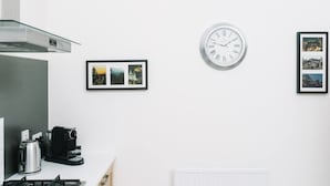 A kitchen with a gas stove, a coffee maker, and a framed photo collection on the wall. - JOIVY Great Location! Heart of City Centre 3bed Apartment (Edinburgh)