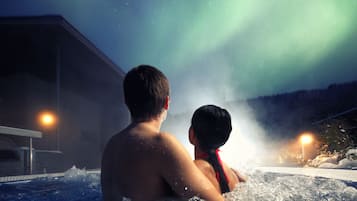 Relax in a serene hot tub with breathtaking views of the Northern Lights.