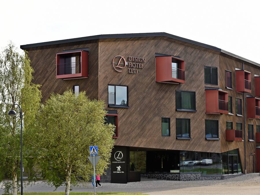 A modern hotel with a distinctive wooden facade and red accents.