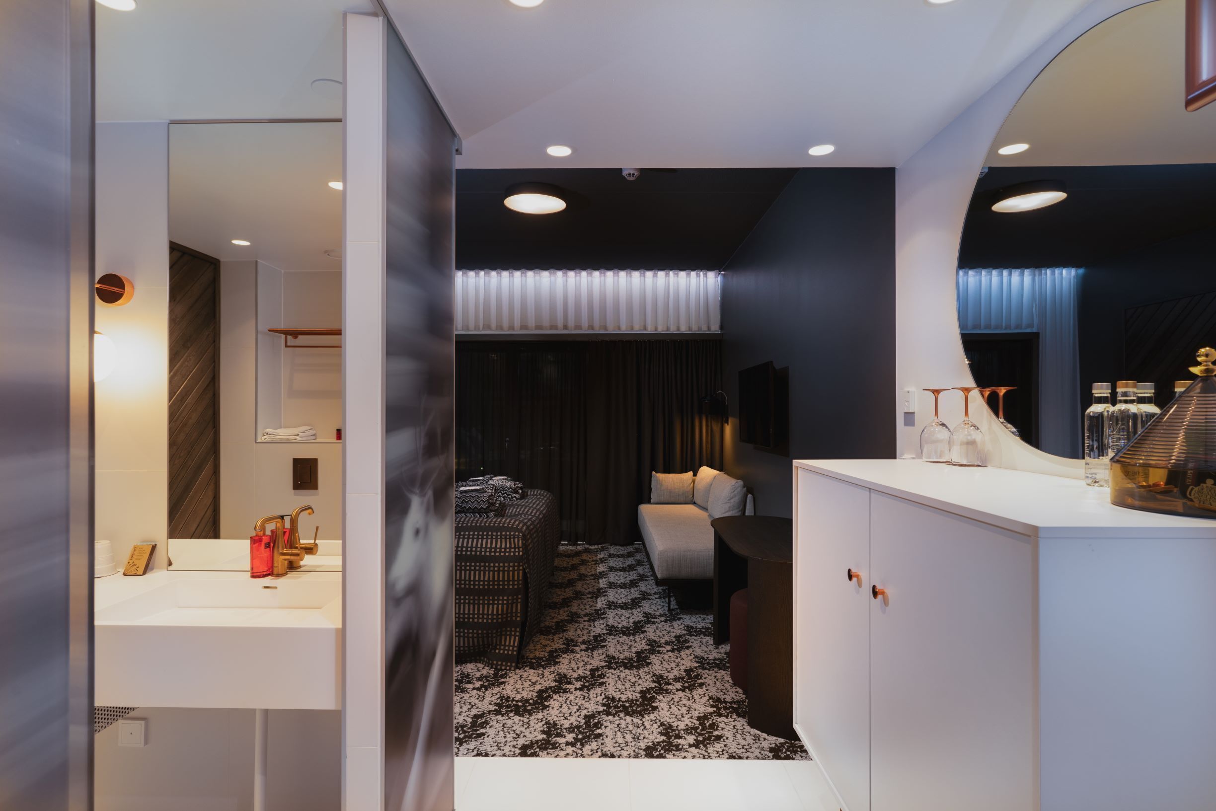 A modern bathroom with a white sink, a mirror, and a towel rack.