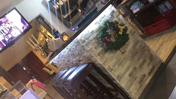 A lobby with a stone wall, a Christmas tree, and a red storage unit. - Hotel Restaurant Memo (Mannheim)