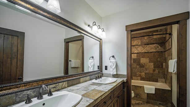 A bathroom with two sinks, a large mirror, and a shower area. - Trailmere Escape with Access to Forest House (Bend)