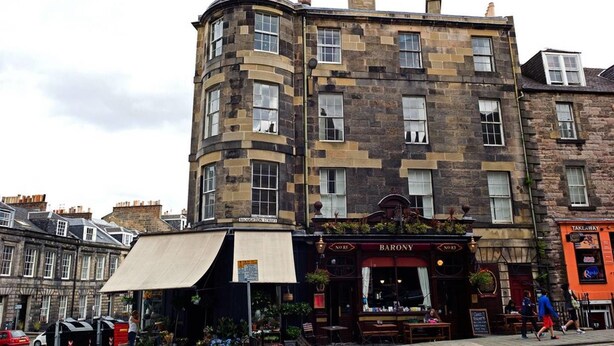 A corner building with a pub named 'Barony' on the ground floor. - JOIVY Bright New Town 2 bed Apt - 5 Mins to Princes St (Edinburgh)