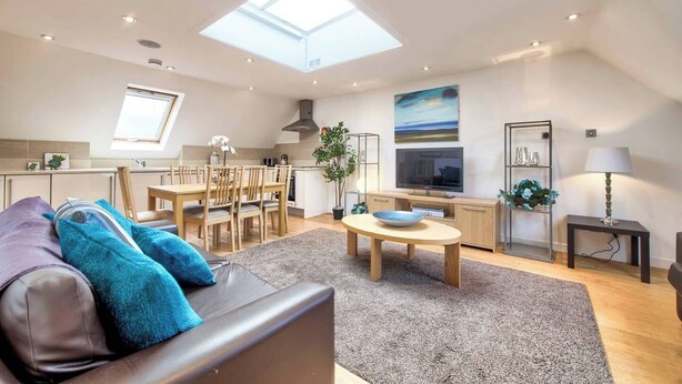 Eine moderne Wohnung mit Essbereich, Küche und Wohnzimmer.