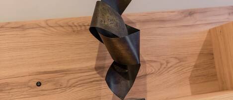 A metal sculpture on a wooden shelf.