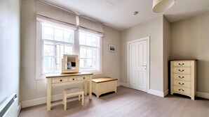 Une pièce comprenant un bureau, une chaise et une commode.
