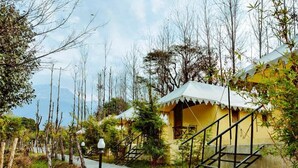 A pathway leading to a yellow building with a staircase and a railing. - Dev Bhoomi Farms & Cottages (Dharamshala)