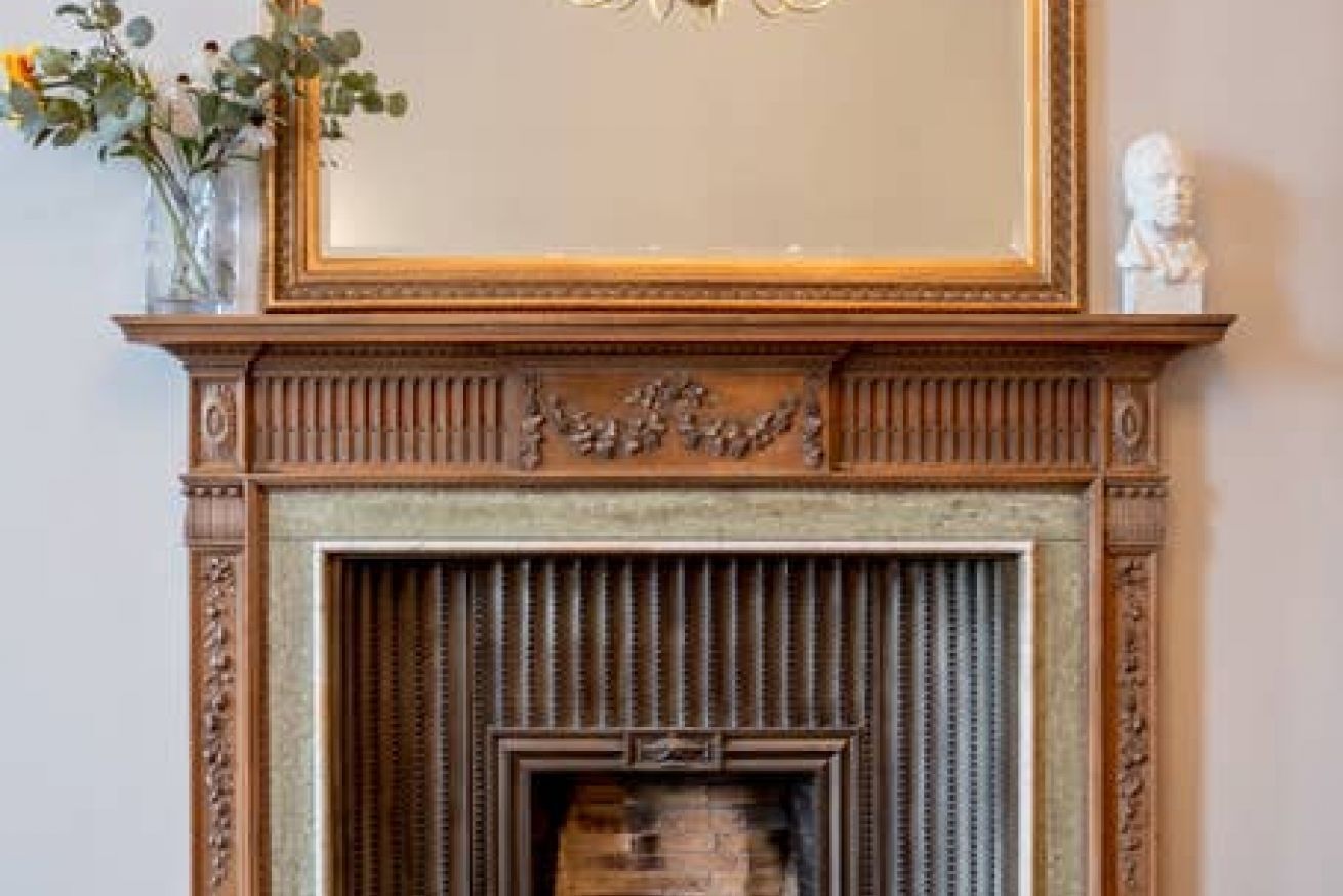 A fireplace with intricate woodwork and a decorative plaque above it.