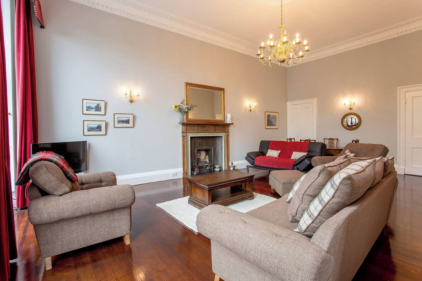 A living room with a fireplace, sofas, a coffee table, and a television.