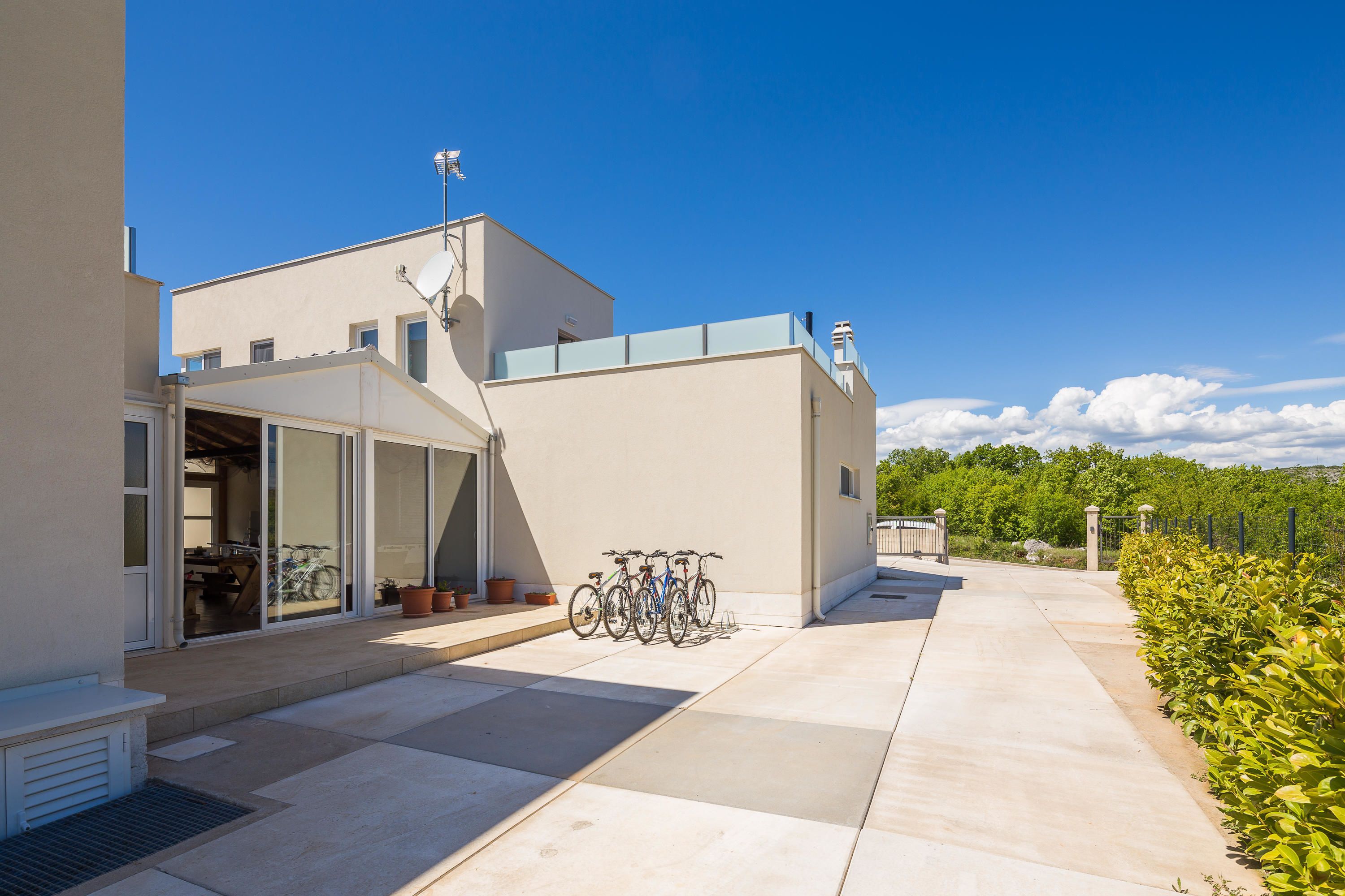 Un edificio moderno con tetto piatto, una veranda coperta e una fila di biciclette parcheggiate fuori.
