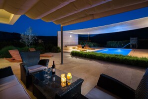 An outdoor patio with a pool, lounge chairs, and a table with drinks. - Stunning Villa Sofia With Heated Pool IN Split Hinterland (Dugopolje)