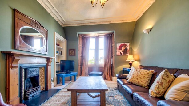 Un salon confortable avec une cheminée, un canapé, une table basse et un téléviseur.