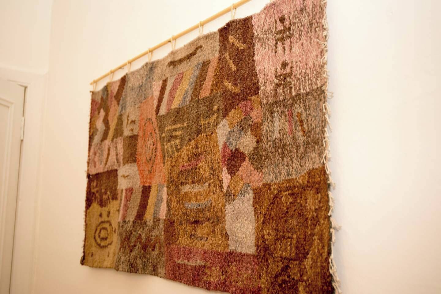 A large, textured artwork hanging on a wall.