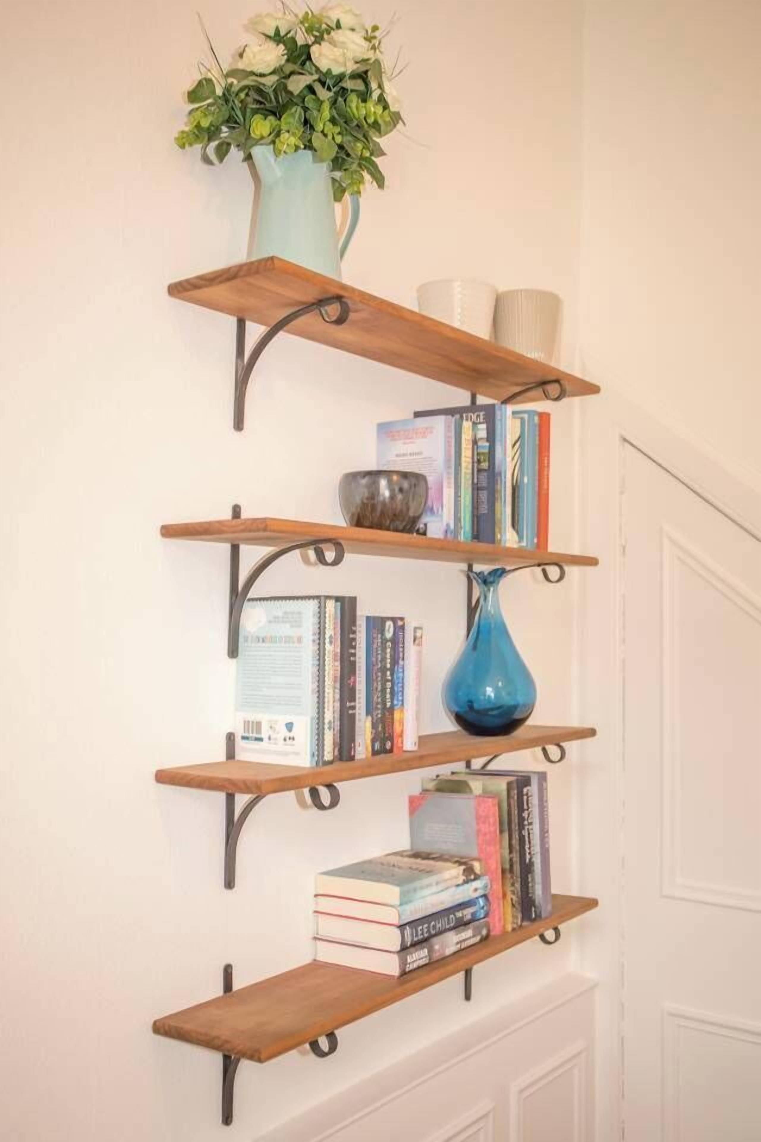 A wall-mounted wooden bookshelf with multiple shelves, each holding books and decorative items.
