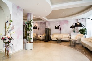 A modern lobby with a curved ceiling, a reception desk, and a seating area with sofas and a coffee table. - Hotel Atlas Leipzig (Leipzig)
