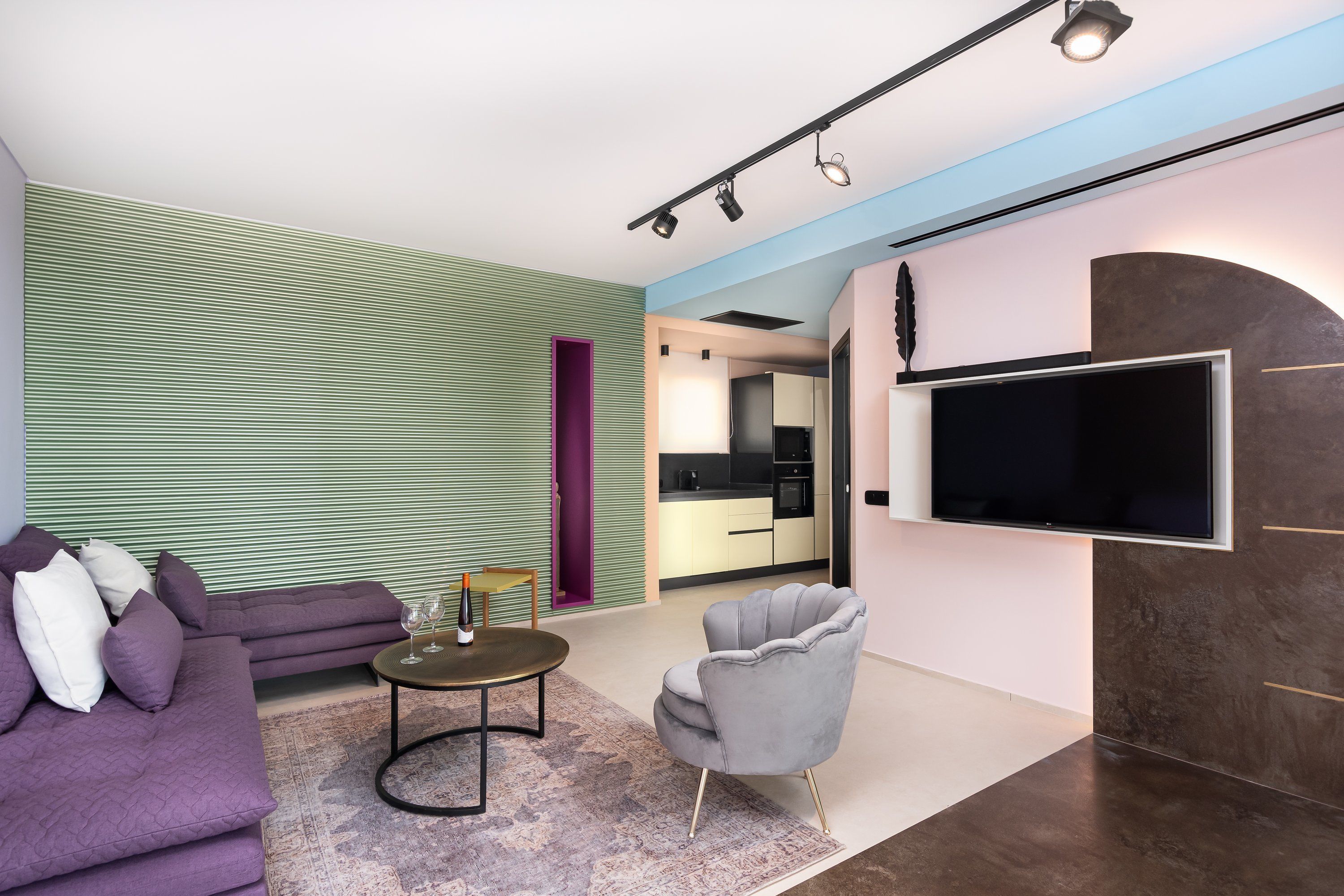 A modern living room with a sectional sofa, a round coffee table, and a grey armchair.