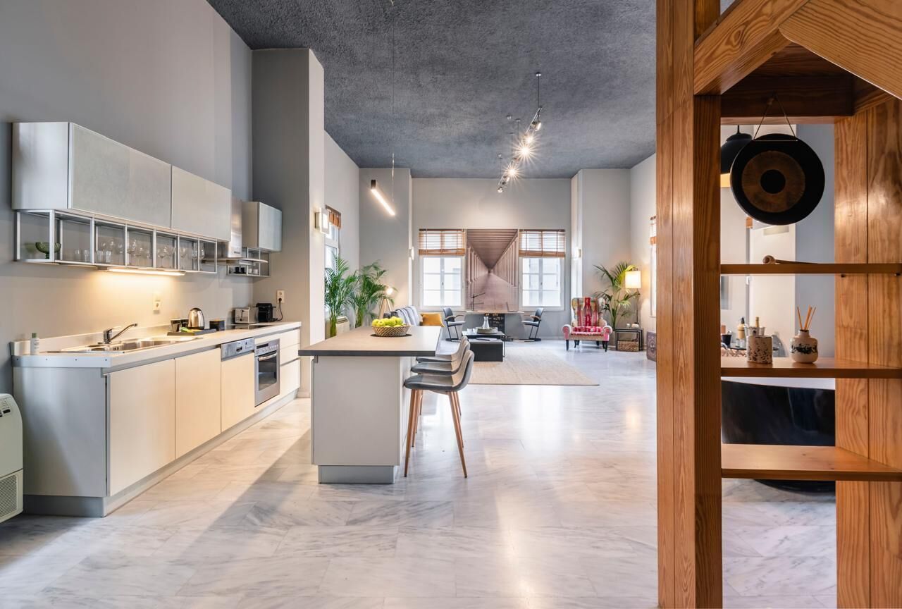Et moderne køkken med en central ø, indbyggede hårde hvidevarer og et spiseområde med udsigt.