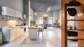 A modern kitchen with a central island, built-in appliances, and a dining area with a view.